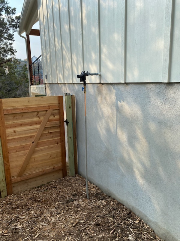 Propane gas line regulator and access point installed on an exterior wall — propane system inspection and repair